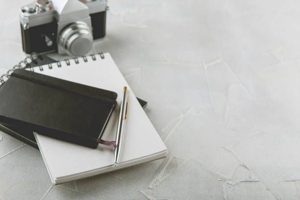 istock Retro photo camera with white note book on a stylish wooden background 1132501778
