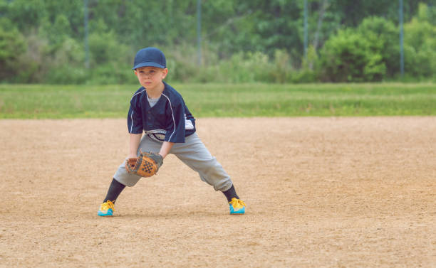 Youth Baseball Player Attentively Playing in the Field A young boy playing baseball stands in the ready position waiting for the ball. youth baseball and softball league photos stock pictures, royalty-free photos & images