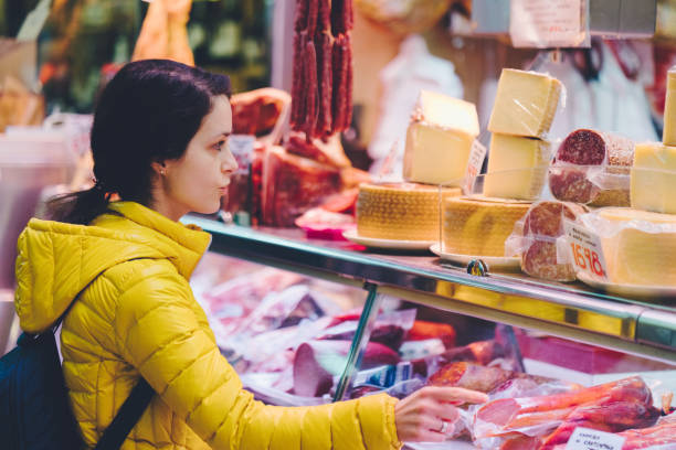 mujer comprando alimentos saludables en el mercado del agricultor - butchers shop meat market pork fotografías e imágenes de stock