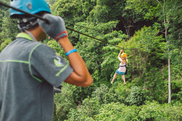 volle länge des frauen-zip-futters im wald - ziplining zip line outdoors zip lining stock-fotos und bilder