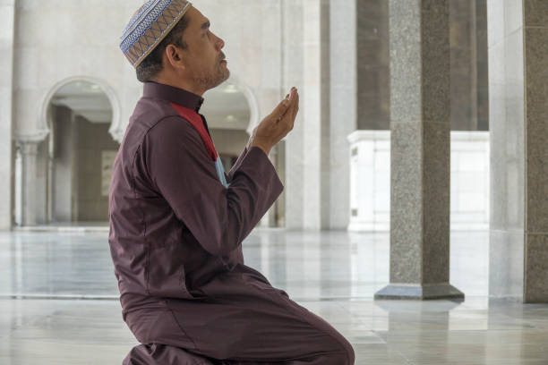 istock Side View Of Mature Man Praying While Kneeling At Mosque 1132510540