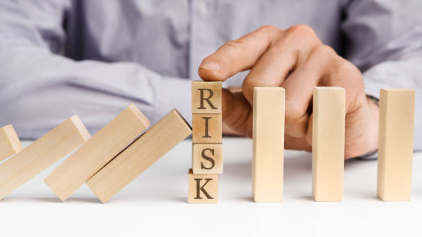 empresario detiene efecto dominó con word risk - analyzing danger risk insurance fotografías e imágenes de stock