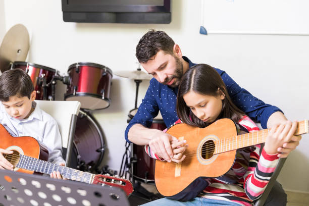 istock Guitar Teacher Giving Personalized Service To Students 1132515894