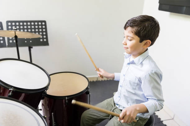 istock Kid Playing Drum In Music School 1132516073
