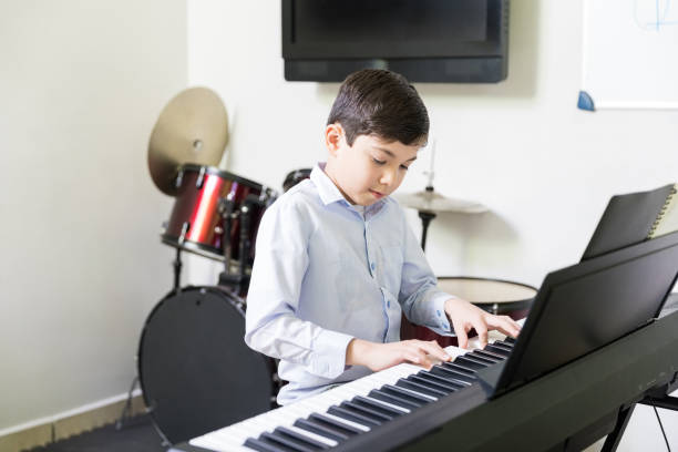 istock Kid Playing Electric Piano In Music School 1132516090