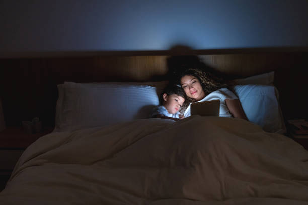 istock Loving mother and son in bed watching videos on a tablet computer 1132516154