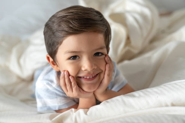 istock Happy boy at home lying in bed and smiling 1132516248