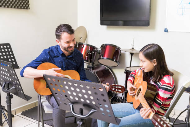 istock Schoolgirl Learning Guitar From Friendly Teacher 1132516399