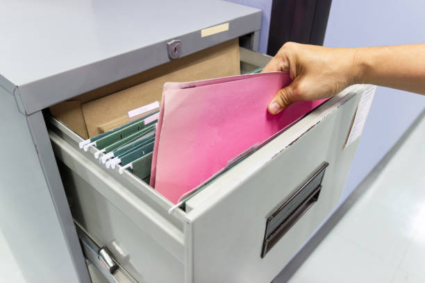 istock Hand of Man Search files document in a file cabinet in work office 1132517468