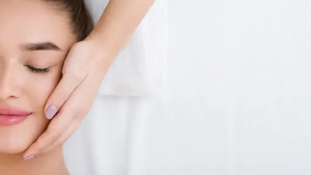 Photo of Woman getting professional facial massage, copy space