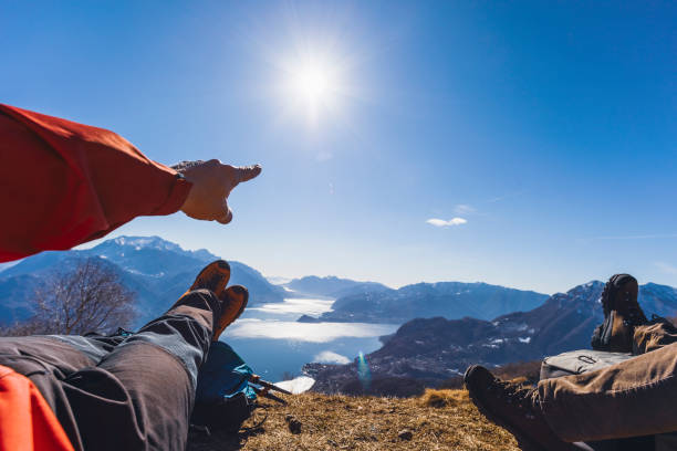 istock Hiker pointing the lake, sun in the clear sky 1132518736