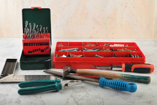 istock Set of construction tools for home on a white cement background. Level, saw, glasses, angle measure, wrench, spanner, paint roll, hammer, cutter, pliers, screws and more. 1132519395