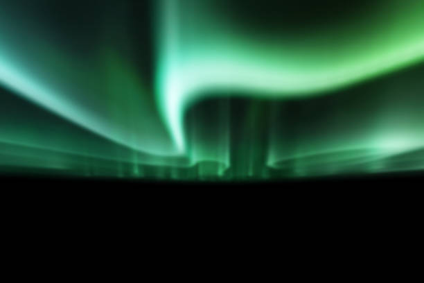 istock green northern lights against black back ground. 1132522394