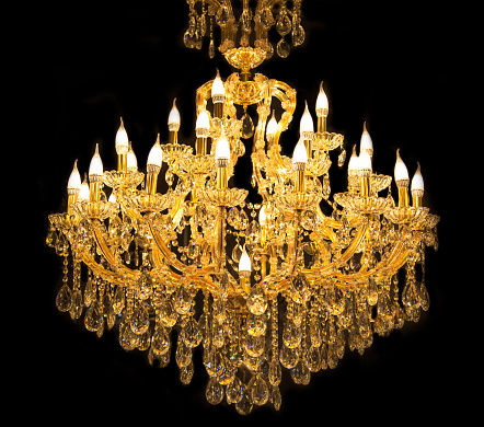 Close up on crystal of contemporary chandelier, is a branched ornamental light fixture designed to be mounted on ceilings or walls. Black background
