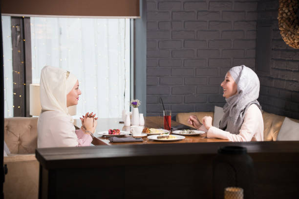 istock Two young Muslim women chatting at a table in a cafe 1132523712