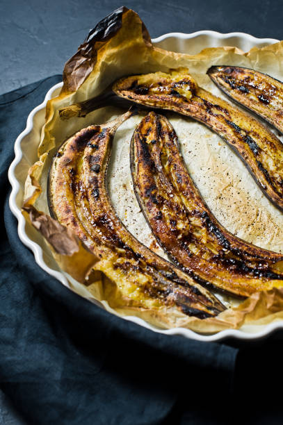 istock Fried bananas with honey in a baking dish. Black background, top view. 1132523734