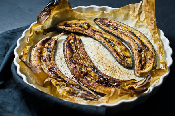 istock Fried bananas with honey in a baking dish. Black background, top view. 1132523802
