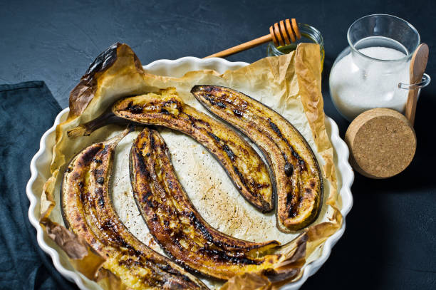 istock Fried bananas with honey in a baking dish. Black background, top view, space for text. 1132524308