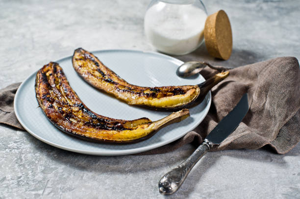 istock Fried bananas with honey on a grey plate. Gray background, side view. 1132525688