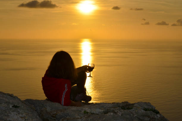 istock Woman raising toast to the setting sun. 1132525701