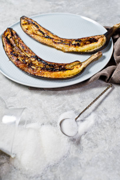 istock Baked bananas with honey on a grey plate. Gray background, side view, space for text. 1132525921