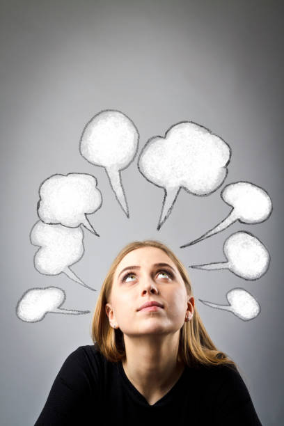istock Young woman in black and blank speech bubbles over her head. Girl solving a problem. 1132527340