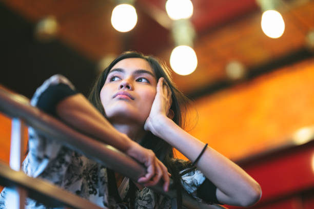 A young woman is looking away in deep thoughts.