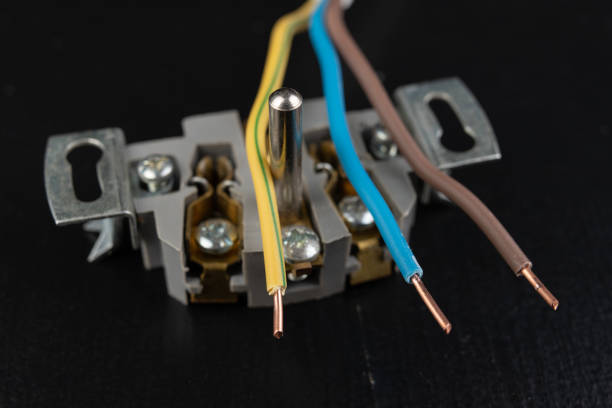 istock Electrical wires mounted to an electrical outlet. Electrical accessories installed in the house. Dark background. 1132534751