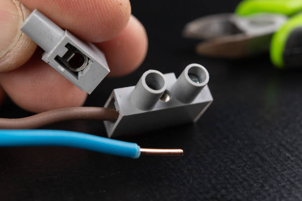 istock Electrical wires mounted to an electrical outlet. Electrical accessories installed in the house. Dark background. 1132535201