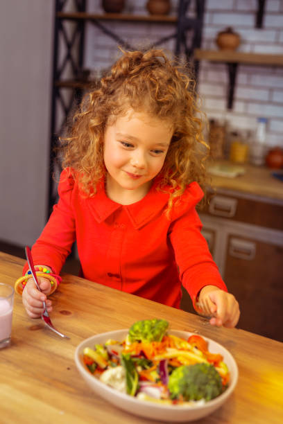 istock Charming blonde little female dreaming about dessert 1132541153