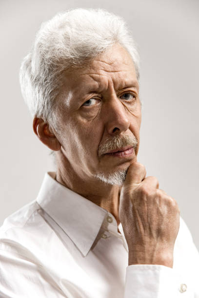 istock The serious businessman against gray background. 1132541765