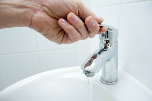 istock Man hand opened the tap with water. Turn on the tap. 1132542568