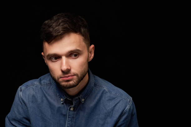 istock Man in denim shirt looking looking down with thoughtful 1132544145