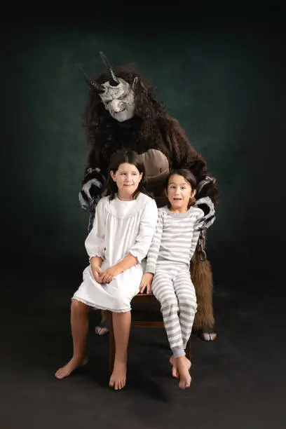 Krampus scares young children in pajamas