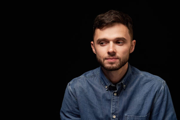 istock Thinking man in denim shirt looking sideways 1132545643