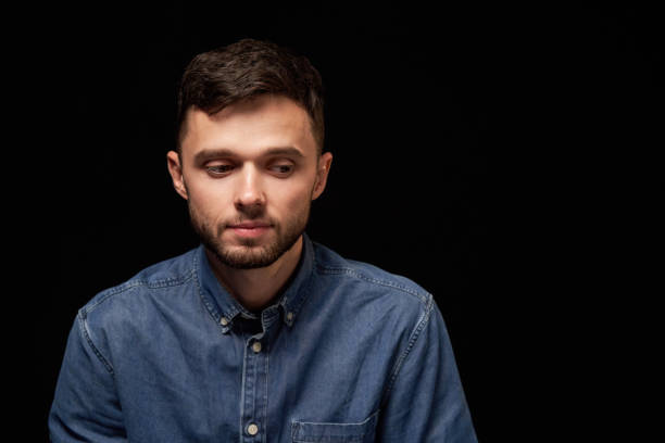 istock Thinking man in denim shirt looking sideways 1132545733
