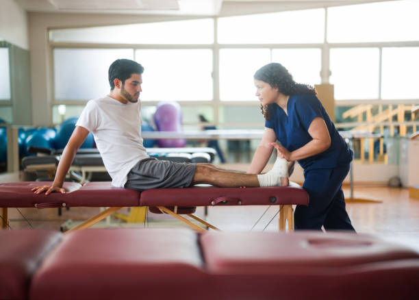 istock Female nurse stretching patient's ankle with bandage 1132546071