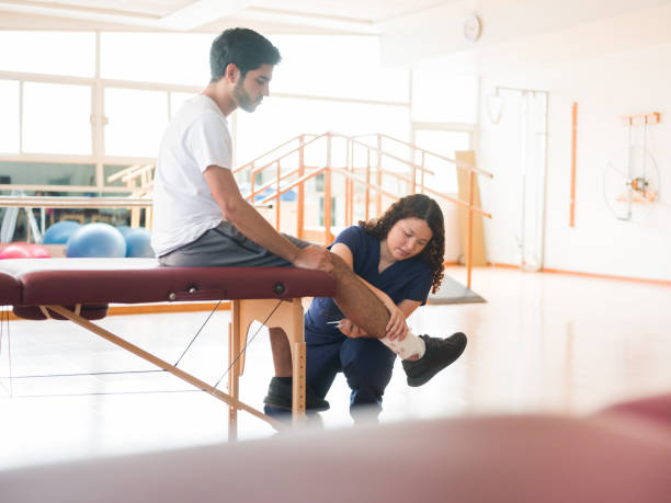 istock Female occupational therapist checking patient's leg 1132546196