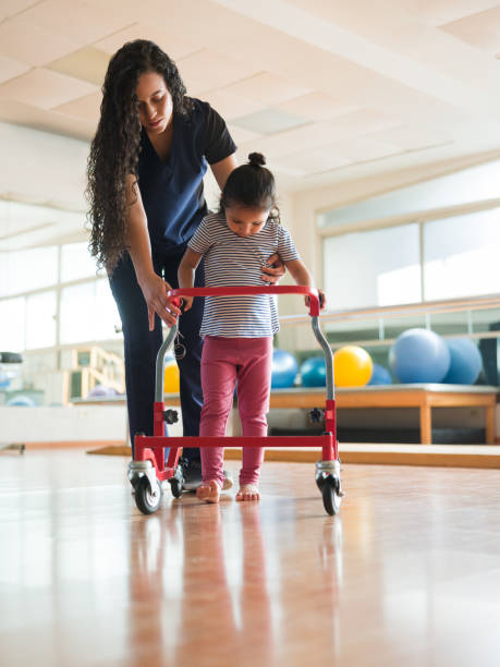 Cute little girl walking with wheeled-walking support
