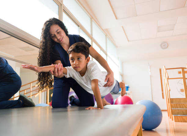 istock Little boy raising arm during physical therapy session 1132546266