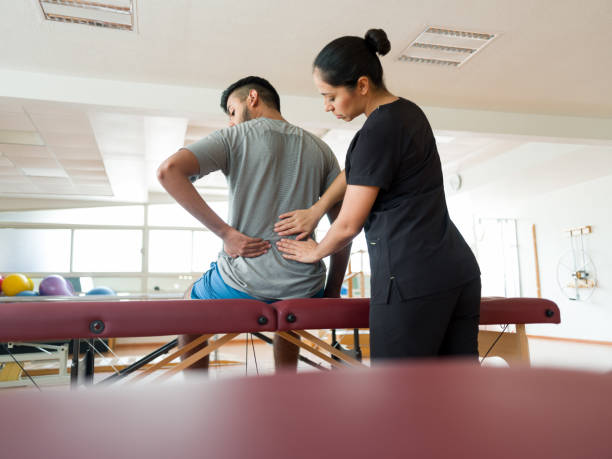 istock Female massage therapist working on patient's back 1132546397