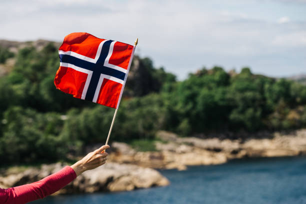 istock Tourist with norwegian flag on sea coast 1132554729