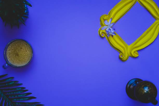 istock Purple background with yellow frame mug of coffee and objects 1132555122