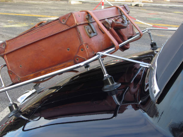Leather suitcase on classic car . Travel concept