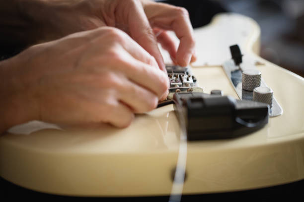 istock Telecaster type electric guitar, seting up strings, close-up 1132555842