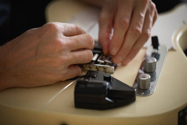 Telecaster type electric guitar, seting up strings, close-up