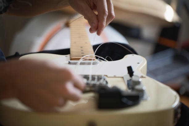 istock Telecaster type electric guitar, seting up strings, close-up 1132555994