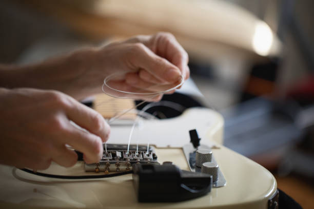 istock Telecaster type electric guitar, seting up strings, close-up 1132556010