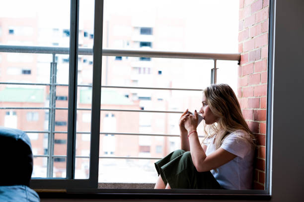 istock Woman sitting on the balcony drinking coffee 1132556085