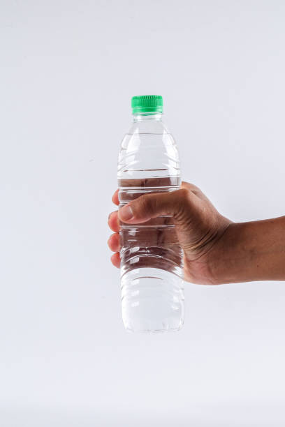 istock Cropped Hand Holding Water Bottle Against White Background 1132556684
